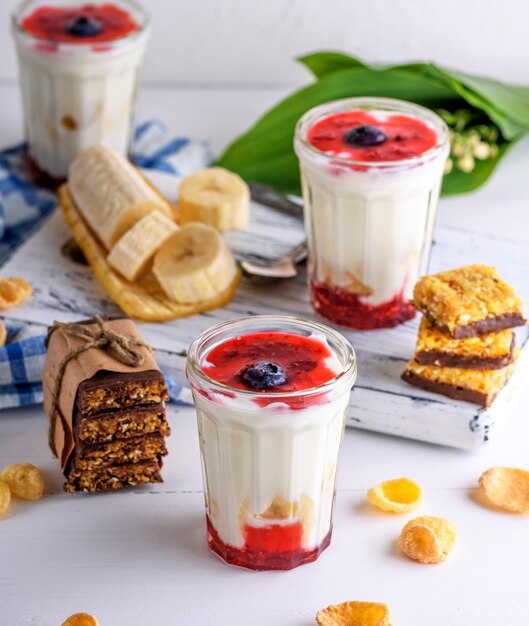 Homemade yogurt in transparent glass with syrup and banana 