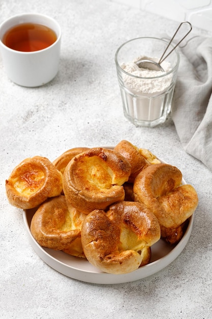 Homemade Yorkshire pudding on plate with tea English traditional food Grey background