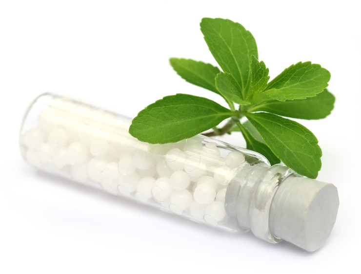 Photo homeopathic globules with stevia over white background