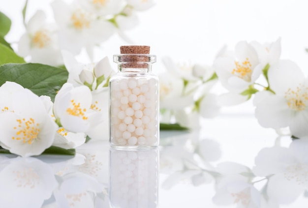 Homeopathische pillen met Lentebloemen op witte houten achtergrond