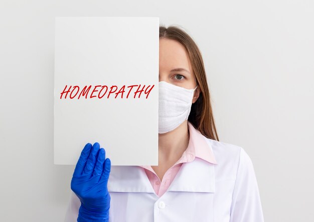 HOMEOPATHY word concept on paper in doctor hands, alternative medicine.