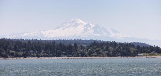 Homes by the beach on the west coast of pacific ocean with snow covered mountain