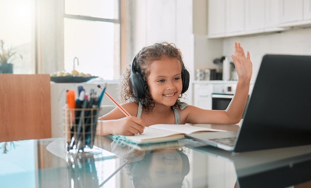 Photo homeschool education and video call distance learning for child on laptop in home living room smile writing and happy girl or waving student greeting on online school and study class for homework