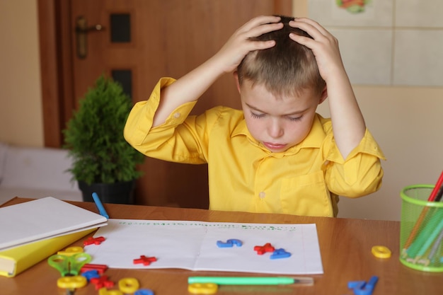 写真 レッスンを学ぶのが難しいホームスクーリングの少年は、疲労感、疲労感、狂気を強調します