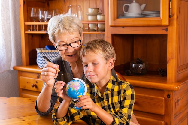 Nonna homeschooling che insegna al bambino intelligente in geografia