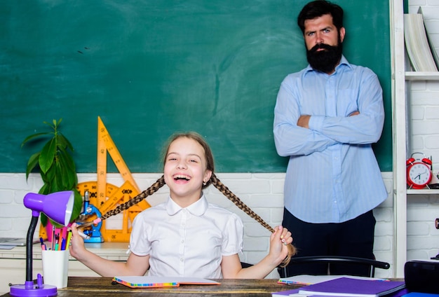 Homeschooling with father Find buddy to help you study Private lesson Pedagogue skills School teacher and schoolgirl Work together to accomplish more Man bearded pedagogue Talented pedagogue