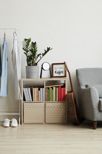 homey apartment interior, focus on small bookstand with decor items and plant