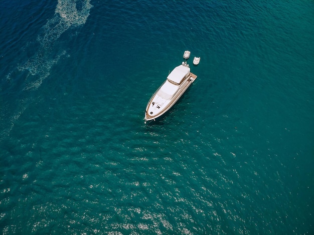 Hommelschot van het mooie witte jacht in de warme blauwe zee; rijkdom concept.