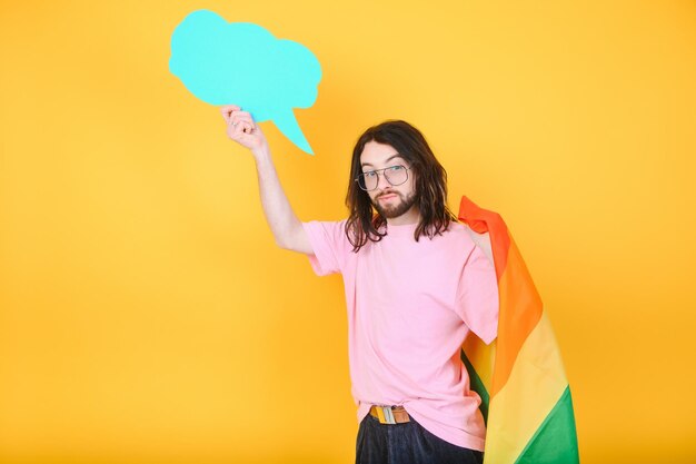 Homo man met felroze top hold regenboog gestreepte vlag geïsoleerd op gekleurde achtergrond studio portret Mensen levensstijl mode lgbtq concept