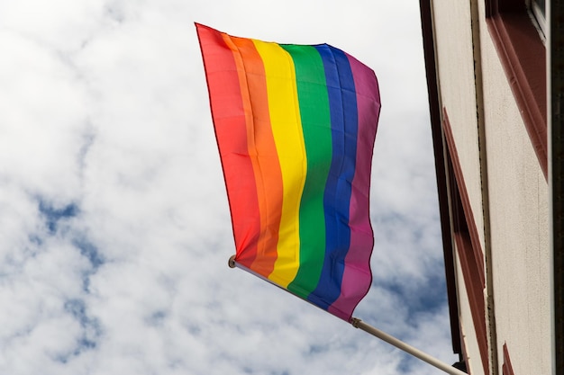 homoseksualiteit, symbolisch en gay pride-concept - close-up van de regenboogvlag die op het gebouw zwaait