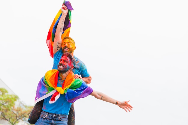 Homoseksueel paar met geschilderde gezichten die zich bij festival verheugen