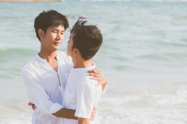 Homoseksueel portret jonge Aziatische paar staande knuffel samen op strand.