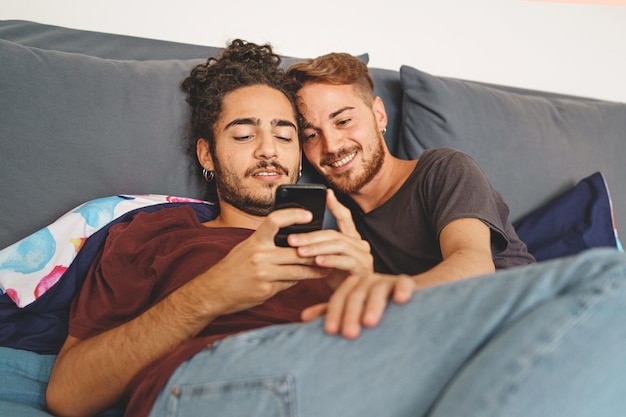 Homosexual male couple watching content online on the smartphone screen