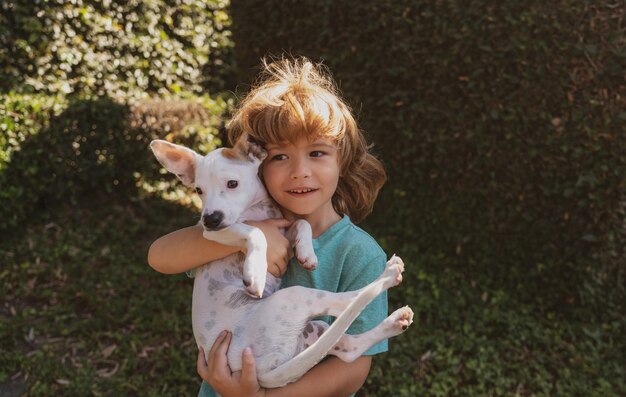 Hond en kind puppy met kind gelukkige jongen knuffelen en spelen met hondje kinderen aanpassing