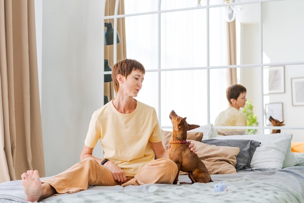 Hond opleiding teams Gelukkige vrouw opleiding huisdier thuis in de woonkamer spelen