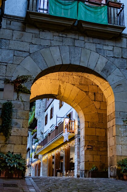 Hondarribia's winter evening tourist explores lit plaza