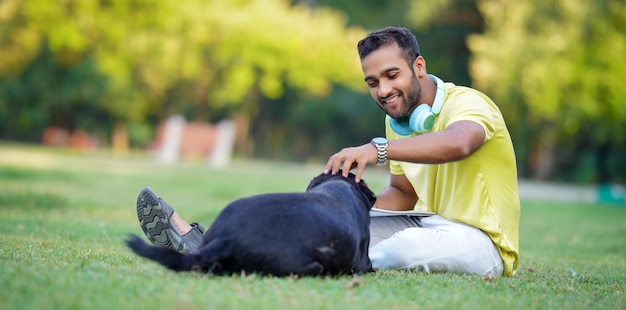 Hondenliefhebber concept Indiase jongen spelen met zwarte hond in park