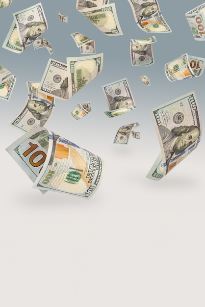 Honderd-dollarbiljetten vallen tegen een blauwe achtergrond. Het concept van rijkdom, grote overwinningen of enorm inkomen. Ruimte om ruimte te kopiëren of tekst te plakken.