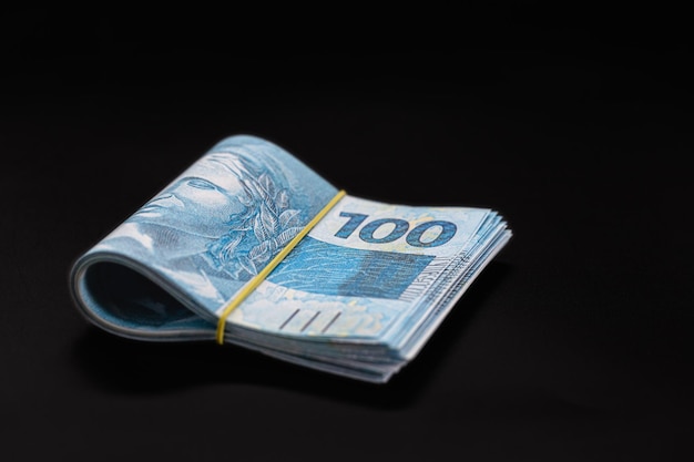 Honderd reais bankbiljetten bundel van geld grote hoeveelheid schuld of financiering concept geïsoleerde zwarte achtergrond