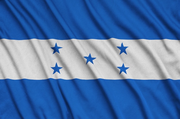 Honduras flag is depicted on a sports cloth fabric with many folds.