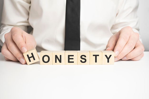 HONESTY Word In Wooden Cube. Businessman hands