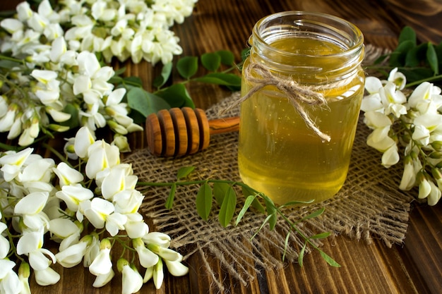 Honey and acacia flowers on the rustic wooden background