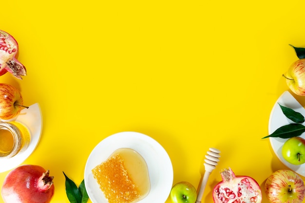 Honey apple and pomegranate on a yellow background concept jewish new year happy holiday rosh