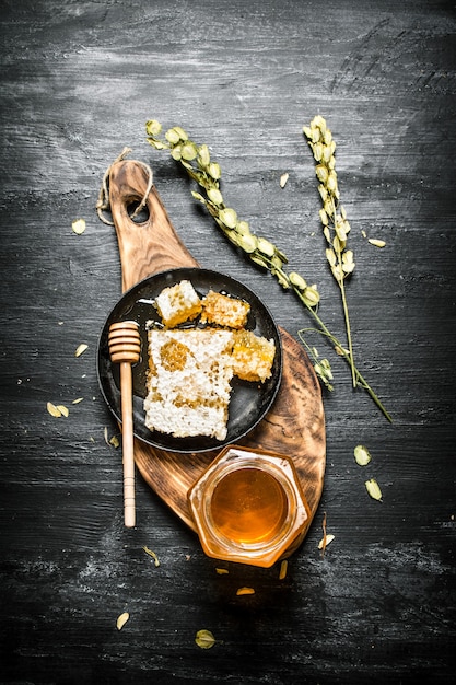 Photo honey background. natural honey and herbs on a wooden board.