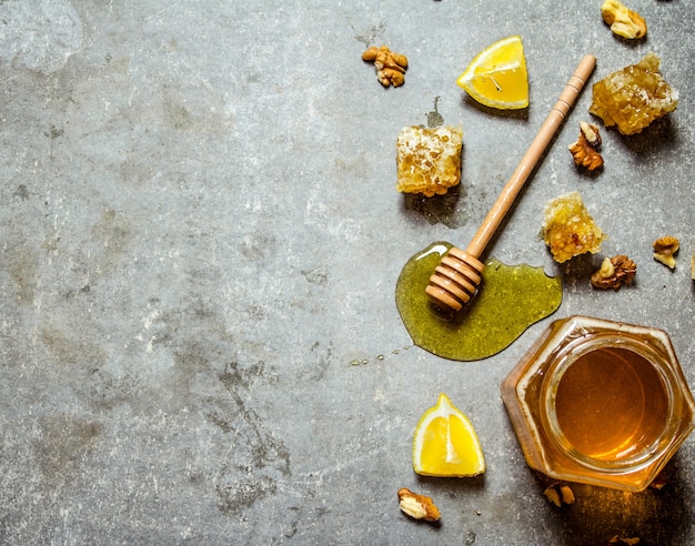 Honey background. Natural honey with slices of lemon and walnuts.