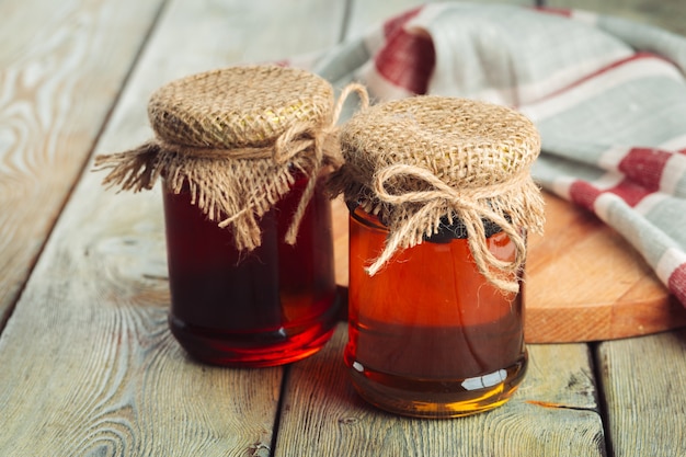 Honey background. Sweet honey in glass jar on wooden background.