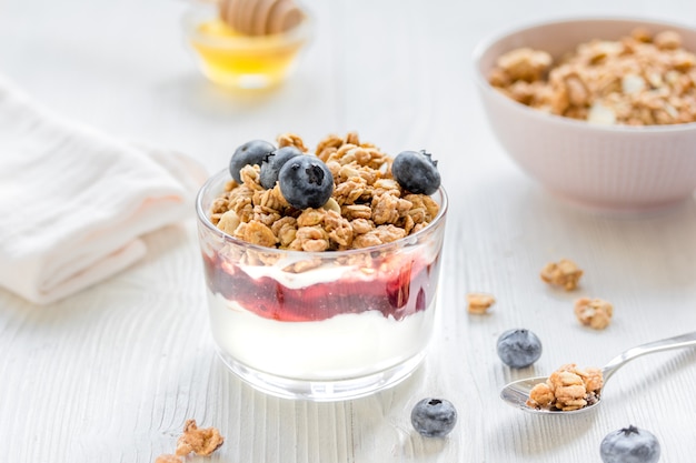 honey and berries on white table