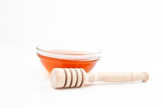 Honey bowl behind a honey dipper