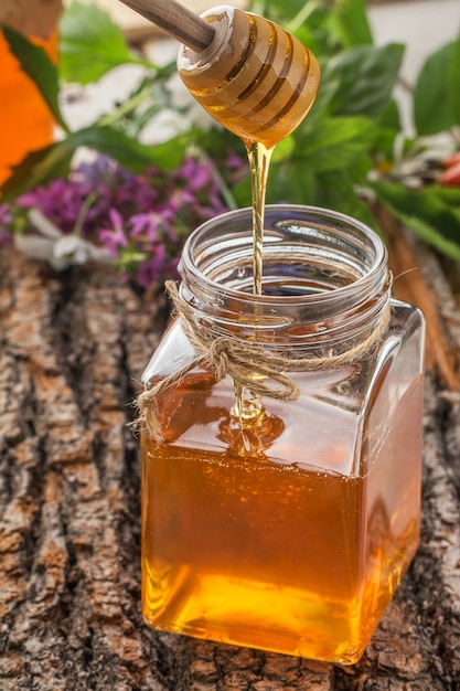 Honey bowl with dipper and flowing honey