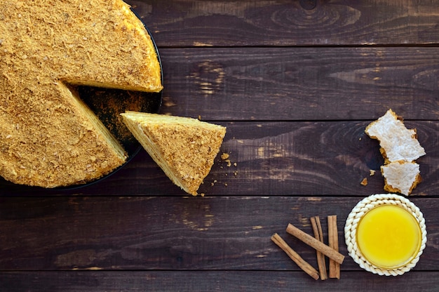 Honey cake on a dark wood. Cutting a piece.