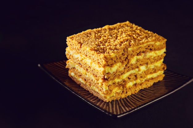 Photo honey cake on plate. dark background