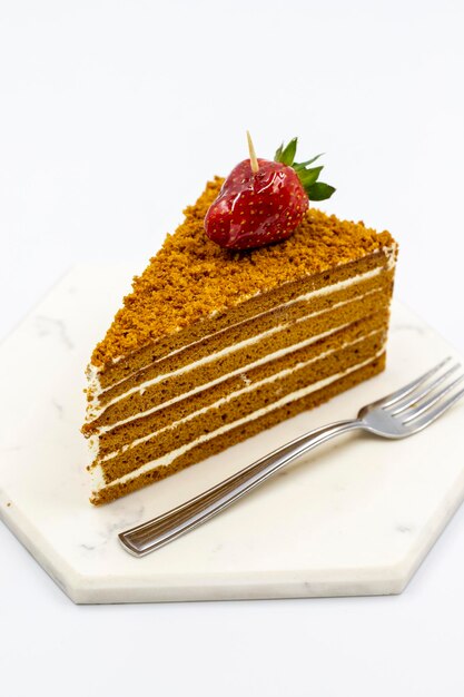 Honey cake on a white background Cake with milk cream filling