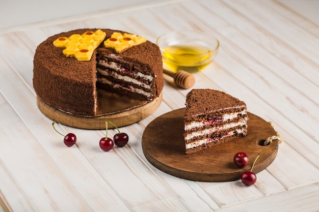 Honey cake with cherries on a white wooden