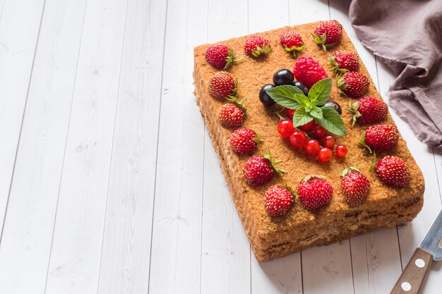 Honey cake with strawberries, mint and currants