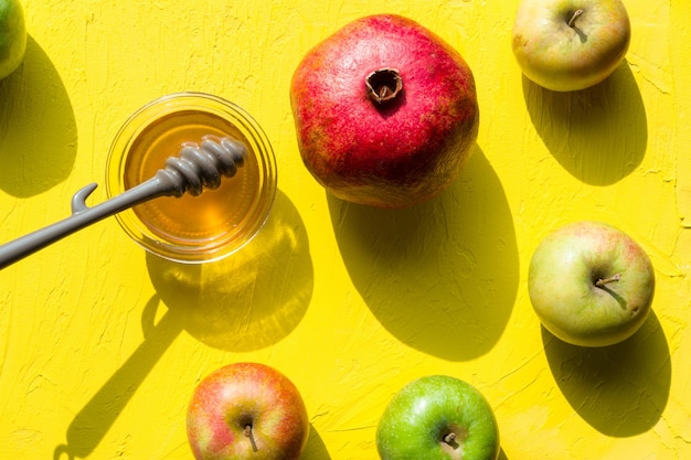 Honey in a cup pomegranate and apples for the Jewish New Year