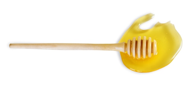 Honey dipper in honey puddle isolated on white