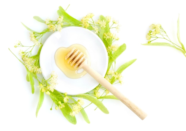 Honey Dipper With Honey With Flowers Of Linden On White Saucer View From Above