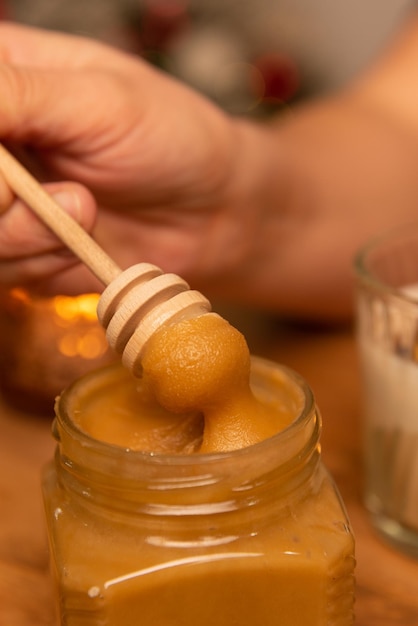 honey dripping from a jar in a christmas new year interior on a wooden table