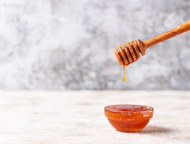 Honey dripping from a wooden dipper