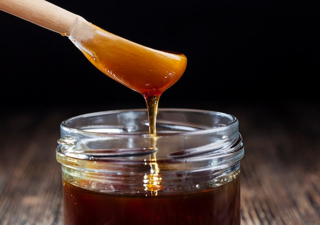 honey flowing into a glass jar