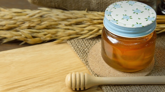  Honey in glass bottle on wood table.