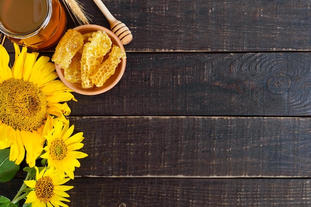 Honey in a glass jar honeycombs Products of beekeeping on a wooden table top view