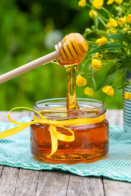 Honey in a glass jar with flowers