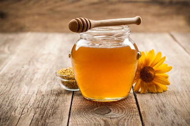 Honey in glass jar on wooden background