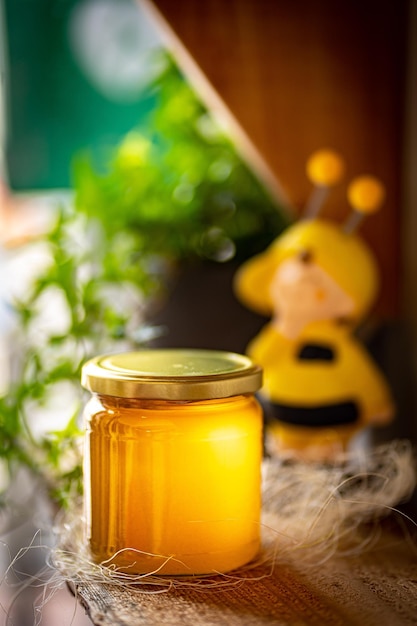 Honey in glass jars with flowers background
