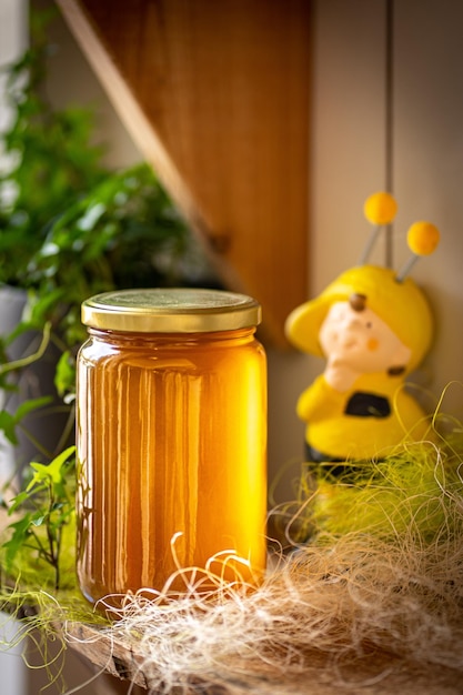 Honey in glass jars with flowers background